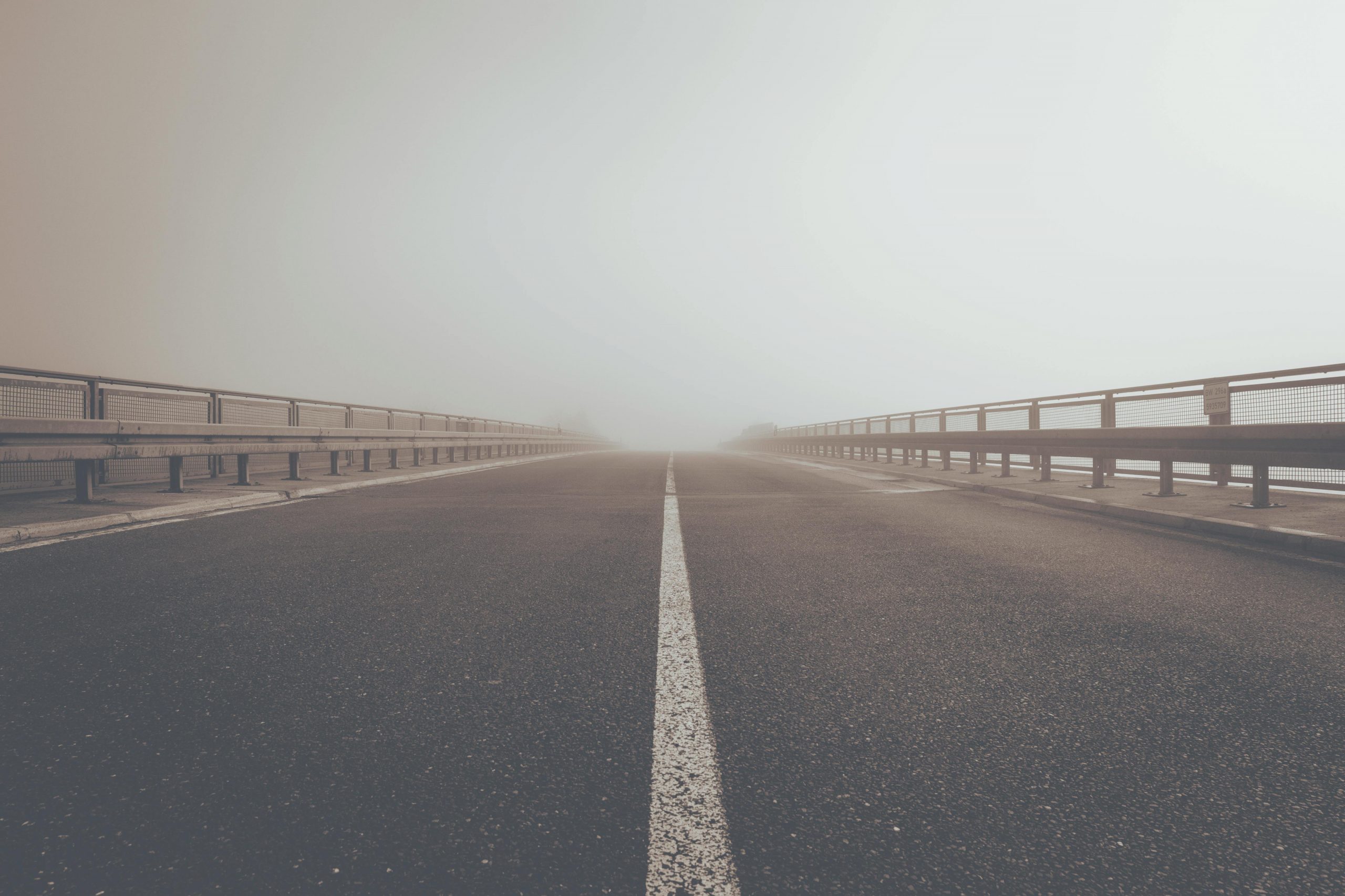 A misty road creating an atmospheric perspective and moody ambiance.